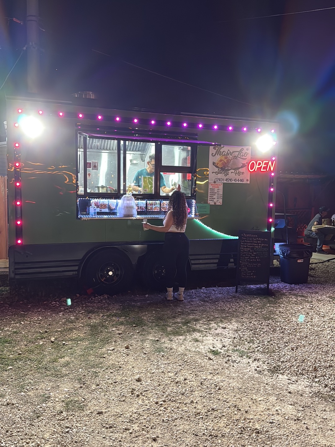 Thai Lao Sticky Rice food truck lit up at night with the OPEN sign